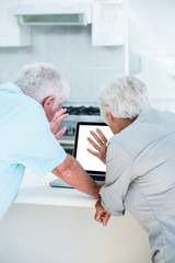Obraz premium Rear view of retired couple using laptop 
