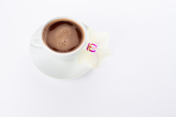 Белая чашка с кофе и цветок орхидеи