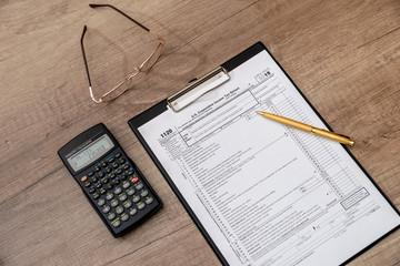 US 1120 tax form, pen, calclator on desk