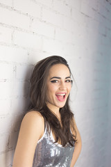 Fototapeta premium Pretty girl smilling and having fun on white bricks wall