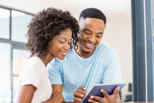 Happy couple using digital tablet