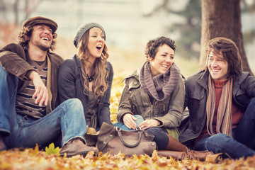 group of Friends having fun at the park  in autumn