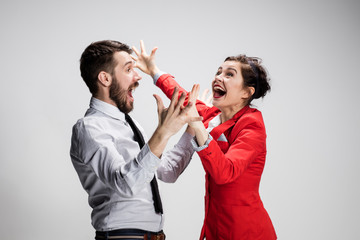The business man and woman laughing on a gray background