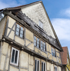 Fototapeta na wymiar Fassade eines alten, baufälligen Fachwerkhaus mit fehlenden Schindeln und maroden Balken