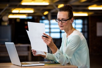 Fototapeta premium Woman reading a document in office