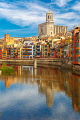 Fototapeta na wymiar Saint Mary Cathedral, colorful yellow and orange houses and famous white house Casa Maso reflected in water river Onyar, in Girona, Catalonia, Spain. 