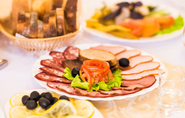 platter of sliced ham,salami and cured meat with vegetable decoration on festive table