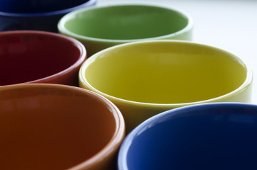 brightly colored ceramic cups on a light background
