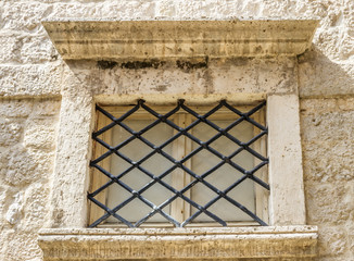 Окно на фасаде каменной стены здания в старом городе Черногории 