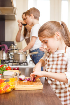 Teenage girl cooking together with her family