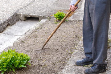 Man rake leaves outdoor at spring