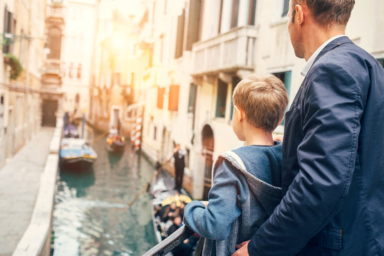 Father and son look together on venecian gondolas