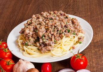 spaghetti with mushroom and minced meat in a plate on wooden table