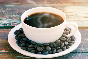 Coffee cup on wooden texture with coffee bean.
