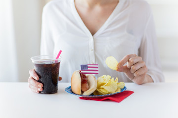 close up of woman eating chips, hot dog and cola