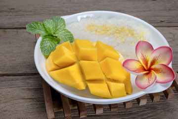 Ripe Mango with sticky rice on wood background