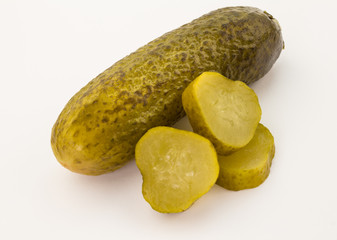 Close up of pickled cucumbers and slices isolated on white backg