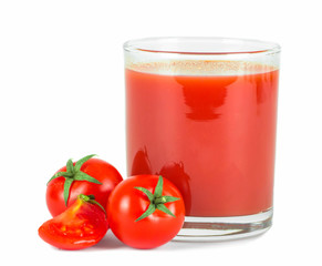 Tomato juice in glass and fresh tomatoes .