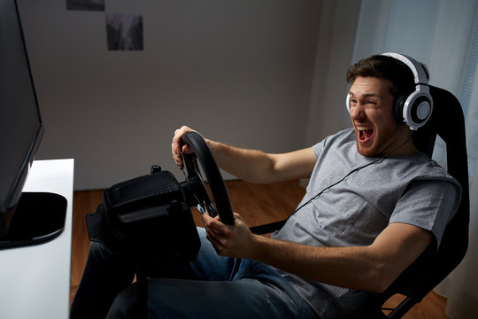 Man Playing Car Racing Video Game At Home