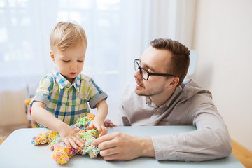 father and son playing with ball clay at home