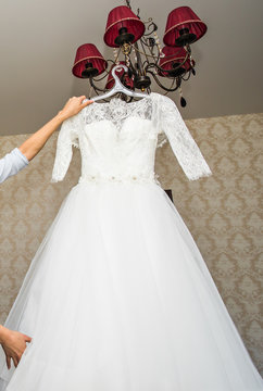 The perfect wedding dress on a hanger in room of  bride 