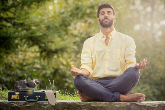 Young yoga position businessman relaxing in nature outdoor