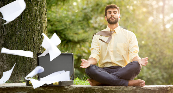 Young yoga position businessman relaxing in nature outdoor