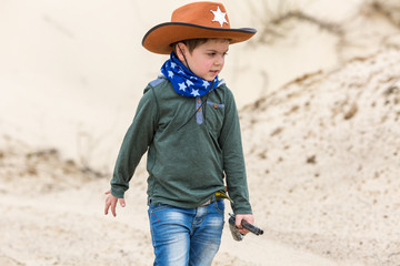 boy in a sheriff hat with a gun