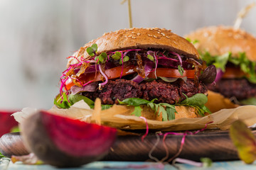 Tasty beef burgers on wooden table.