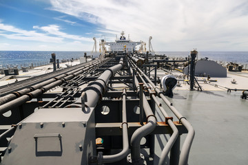 Deck of new oil tanker in sea under blue sky.