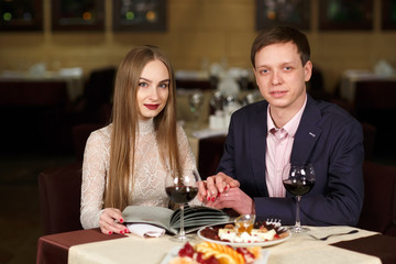 Cheerful couple with menu in a restaurant.