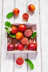 Juicy blood oranges, whole and half, on a white background