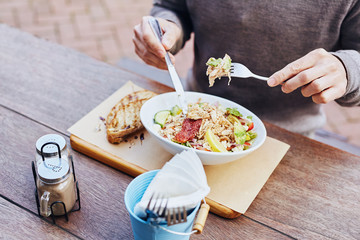 Man eating healthy chicken salad at a cafe