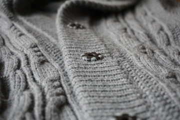 Fototapeta na wymiar Detail of gray metal buttons fastening the woolen sweater