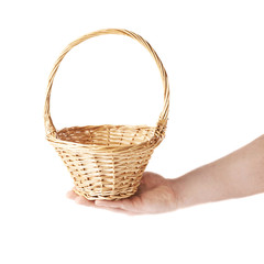 Hand holding a wicker basket, composition isolated over the white background