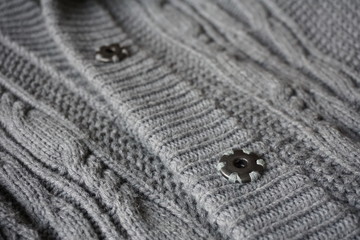 
Detail of gray metal buttons fastening the woolen sweater