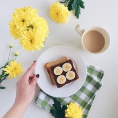 A toast with coffee and yellow flowers