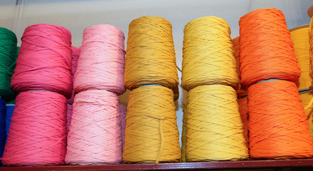  colored spools of thread and balls of wool for sale in the shop
