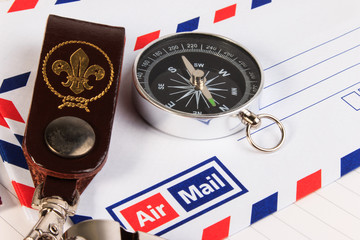 Metal whistle with leather keychain, compass, badge on envelopes