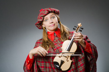 Fototapeta premium Woman in scottish clothing in musical concept