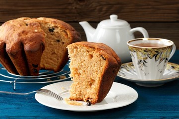 Gugelhupf piece with tea on wooden background