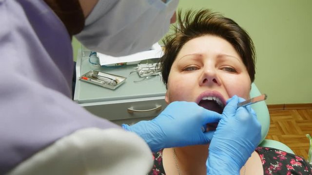 4k Young female patient takes a dental attendance in the dentist's office