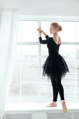 Fototapeta na wymiar ballerina in black tutu over white window