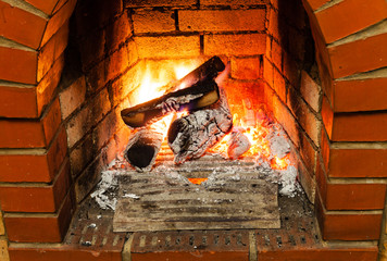 ash, coal and burning firewood in fireplace