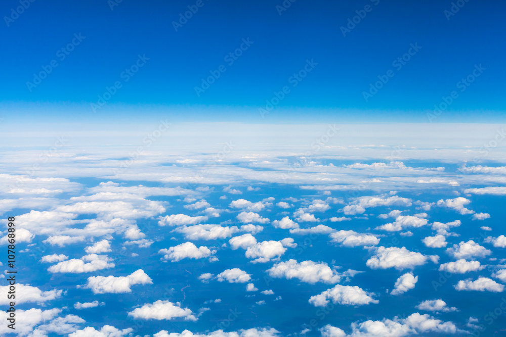 Wall mural above view many little clouds in sky from airplane