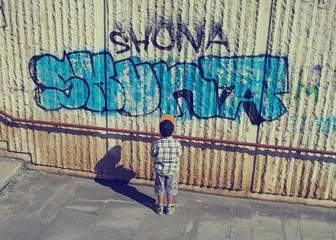 Little Boy Looking At Graffiti