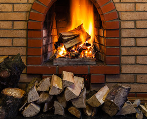 stack and burning wood in indoor brick fireplace