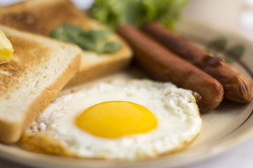 gezond ontbijt gebakken ei gele dooier, toast brood, worst, groente in de ochtend, heerlijke sandwich dieet lunch