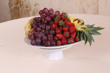 grapes, pineapple, bananas and fresh strawberries on the plate