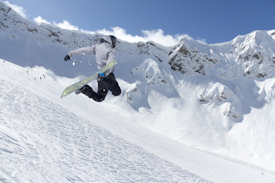 Snowboard rider jumping on mountains. Extreme snowboard freeride.